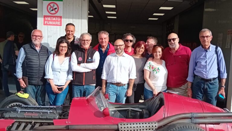 Giornalisti siciliani dietro alla Maserati 250F a Pergusa durante il benvenuto a piloti e team della esclusiva Settimana Motoristica Ennese